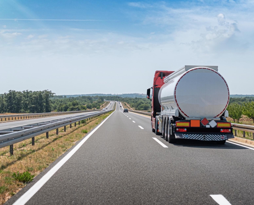 Back view of a semi truck driving down the road