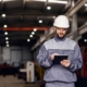 Focused Heavy Industry Worker Uses Tablet In Facility