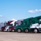 Side View Of The Fronts Of Many Semitrucks Lined Up